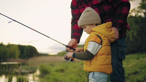 four years old boy is learning to fish grandfather is teaching grandson and helping