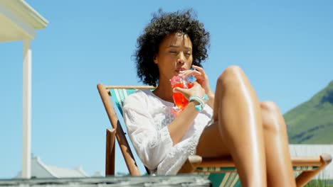 fron view of young mixed frace woman relaxing on sun lounger in the backyard of home 4k