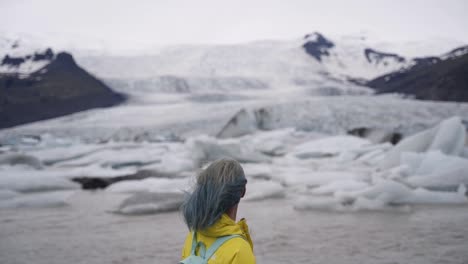 this is a lady enjoying her view of nearby glaciers in iceland.