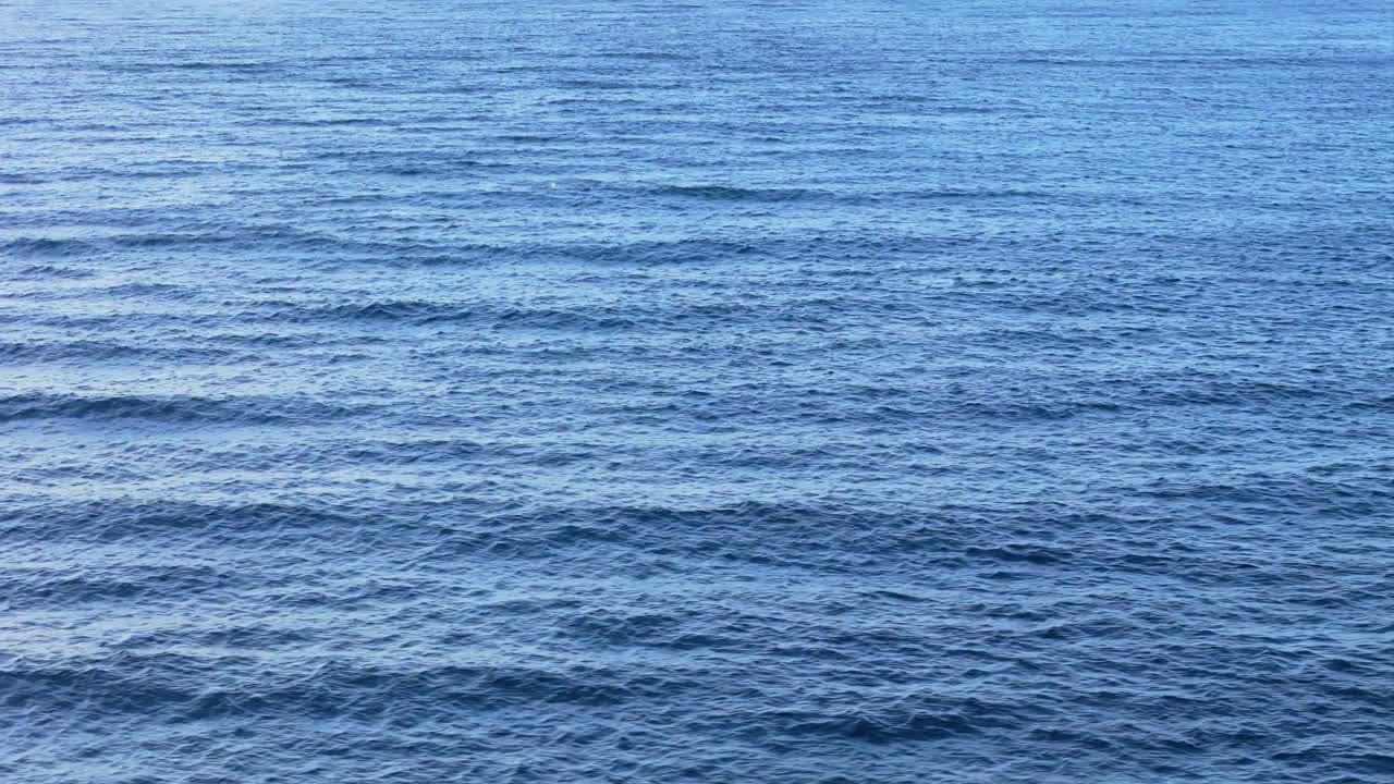 드론은 바다를 가로질러 돌고 있는 바다 파도 흐름을 중심으로 도에 서 있습니다.