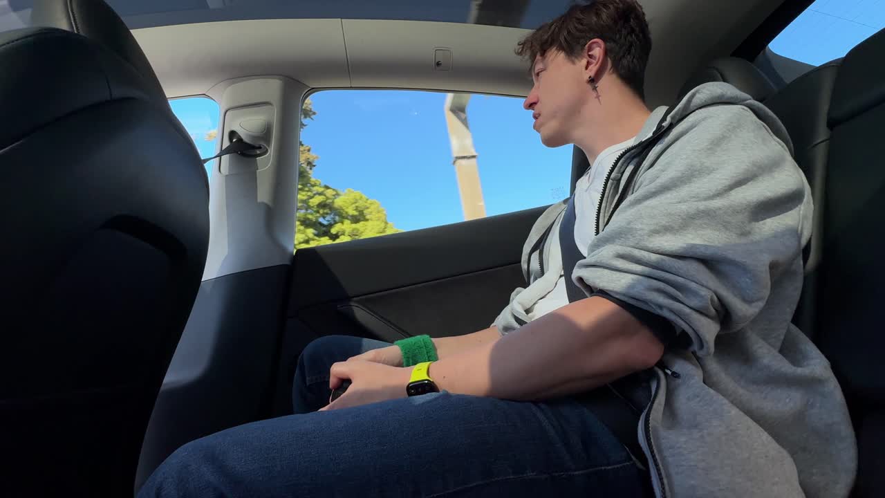 Person sitting in the backseat of a Tesla car