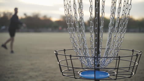 Disc-Golfer-Makes-Second-Putt-in-Disc-Golf-Basket-during-Putting-Practice-for-a-Disc-Golf-Tournament