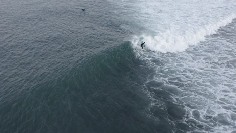 aerial of surfer hitting gnarly wave in turbulent cold water of iceland