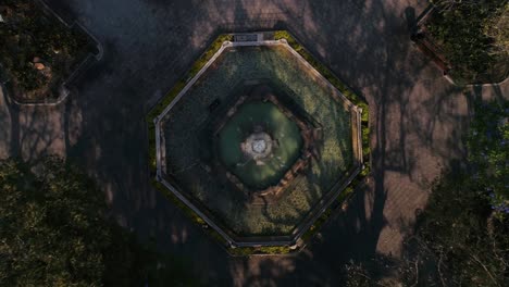 Explore-an-exquisite-symmetrical-fountain-from-above,-surrounded-by-lush-greenery