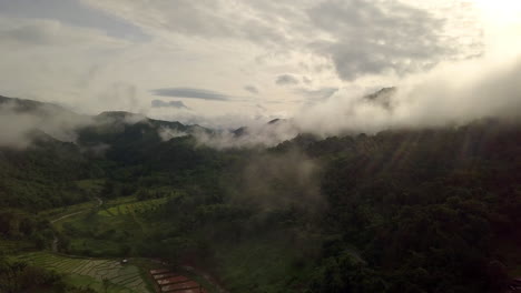 Aerial-view-flying-thru-the-morning-rain-cloud-covered-tropical-rain-forest-mountain-landscape-during-the-rainy-season-on-the-Doi-Phuka-Mountain-reserved-national-park-the-northern-Thailand