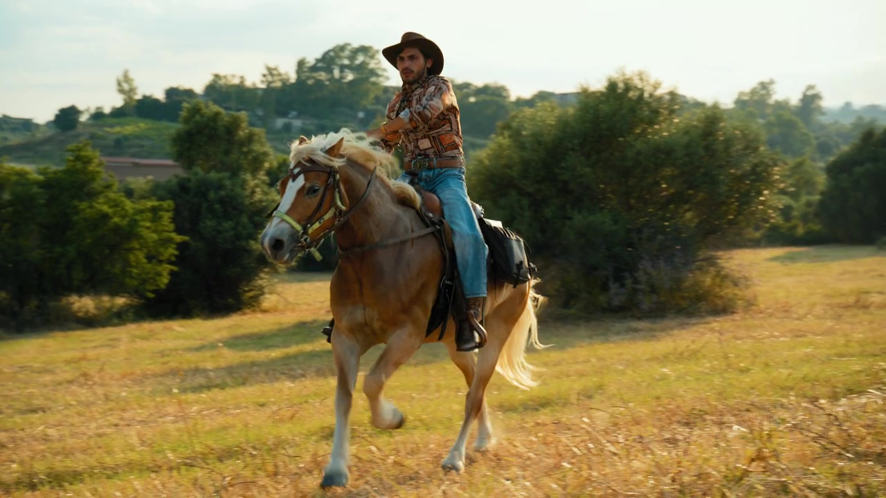 Un hombre galopa a caballo por la naturaleza salvaje al atardecer en Calabria.