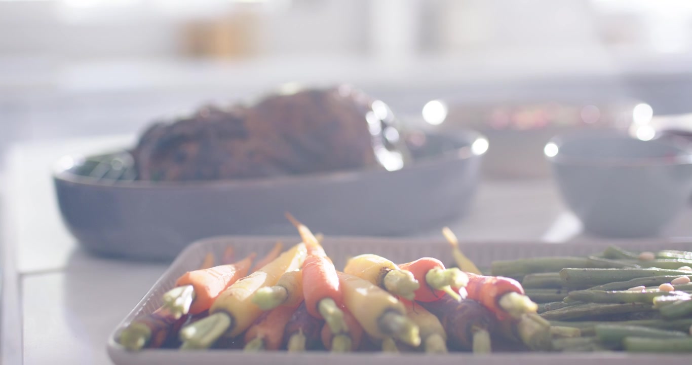 La telecamera sposta il fuoco mettendo a fuoco gli asparagi mentre l'arrosto si ammorbidisce per evidenziare il piatto in primo piano.