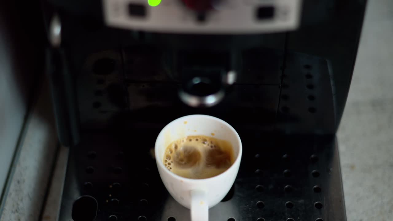 Close up of coffee pouring from a machine in a espresso cup