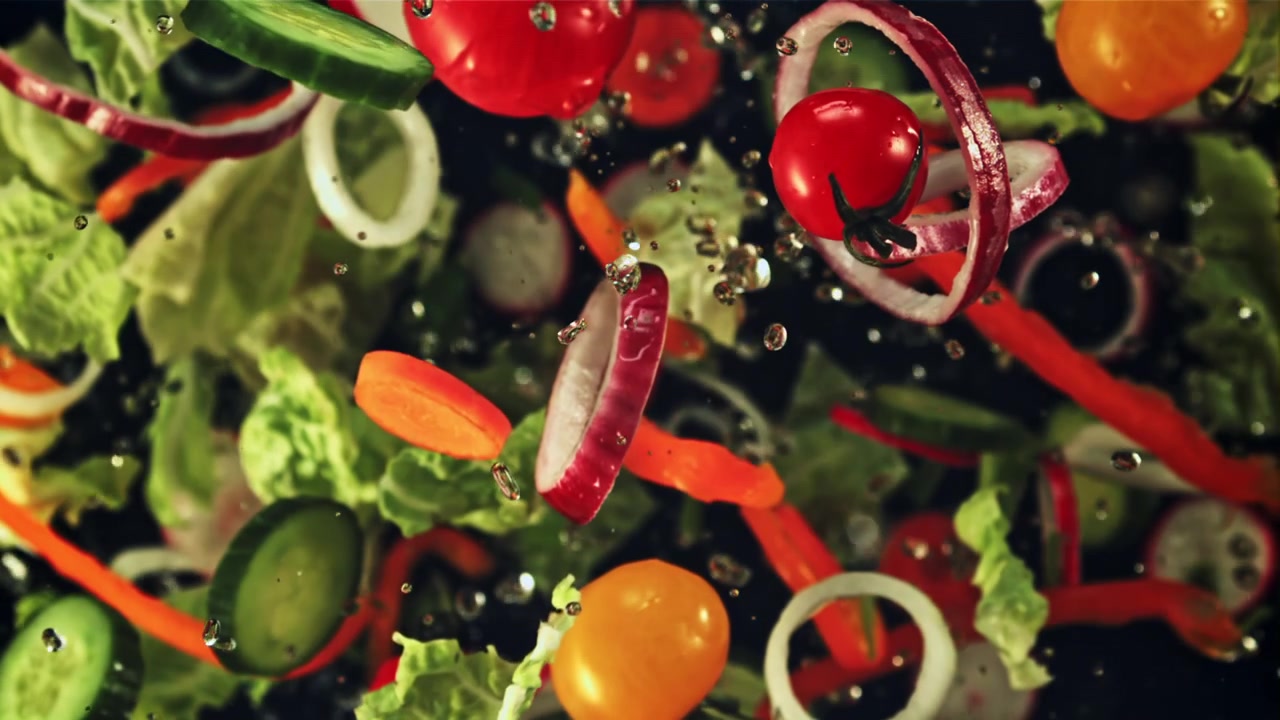 Ingredienti freschi per insalata che cadono e si mescolano al rallentatore.