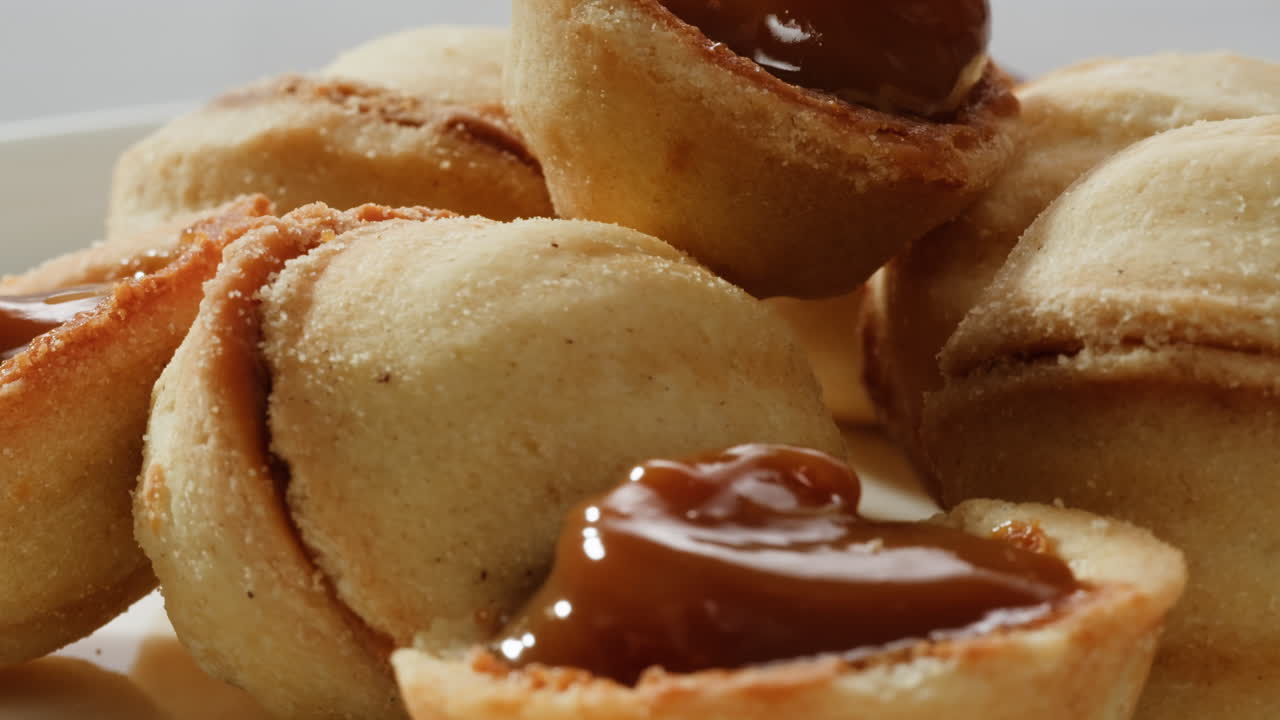 집에서 만든 견과류 모양의 쿠키와 여진 응축 우유가 회색 테이블에 평평하게 놓여 있습니다. 고품질의 4k 영상