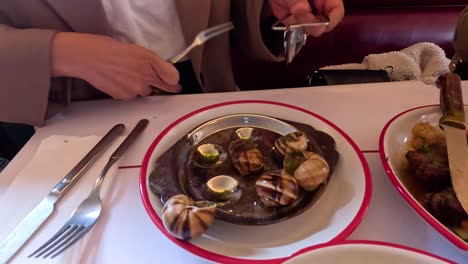 person enjoying escargot at a parisian restaurant