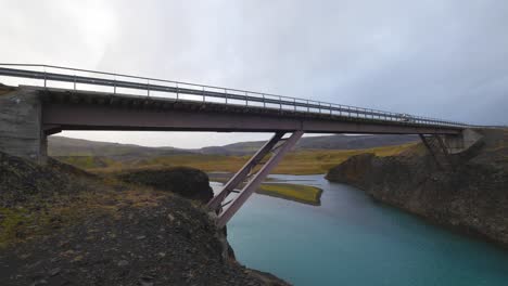 car crossing a pink bridge in iceland. cloudy day