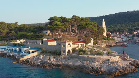 aerial shot circling a boardwalk at veli losinj, croatia on a bright clear day