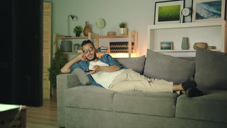man watching tv on couch at night