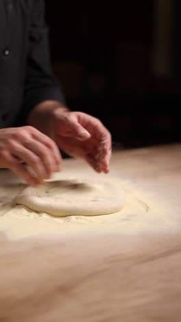 chef kneading pizza dough