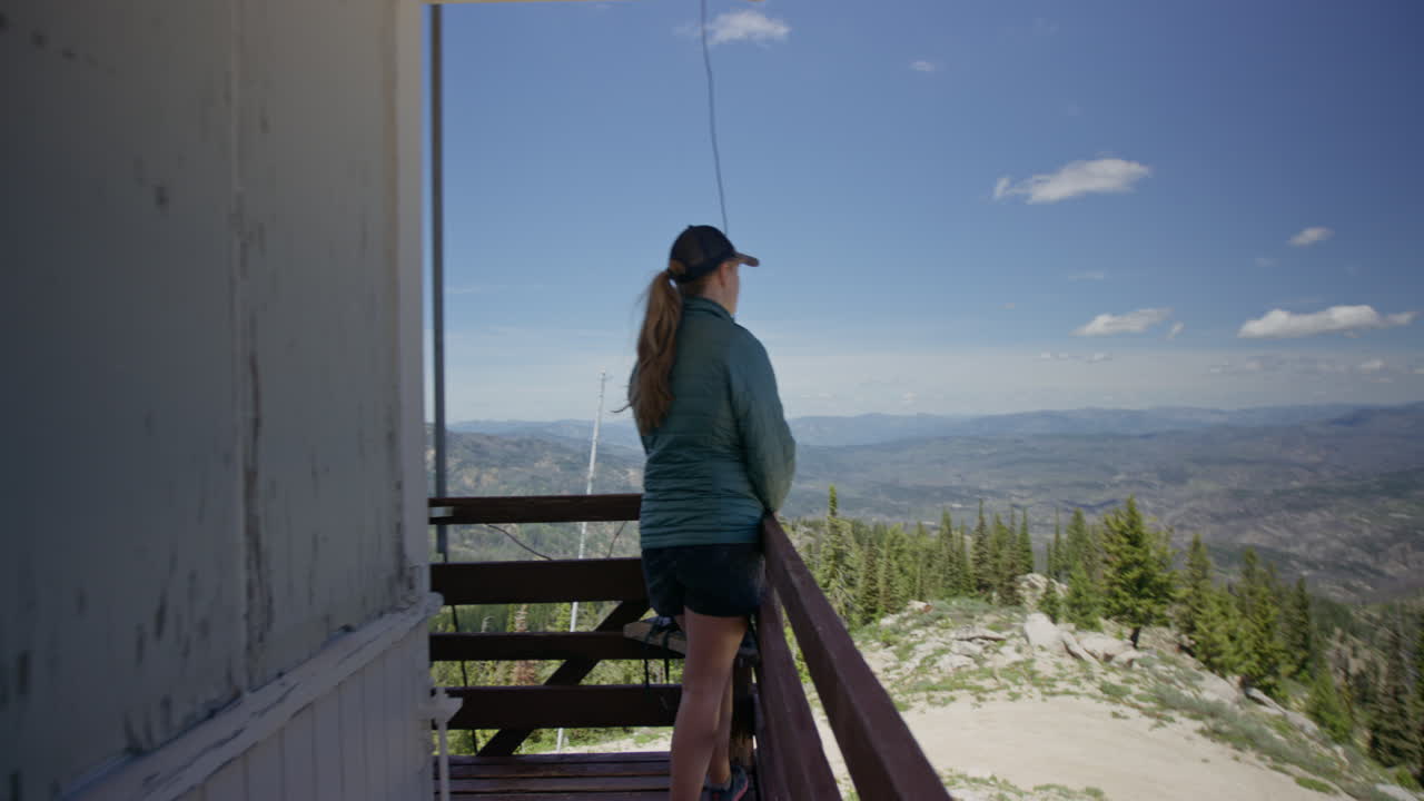 mujer joven mira la vista escénica desde el mirador de las montañas y el bosque