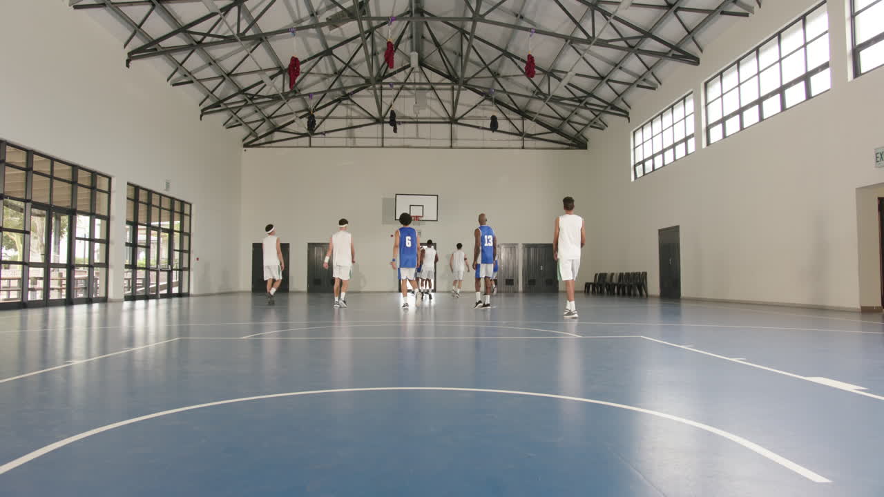 Basketballtrening i gymsal, spillere forbereder seg til konkurransepreget skolekamp