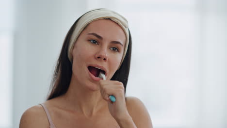 smiling lady doing dental hygiene at bathroom close up. woman removing plaque