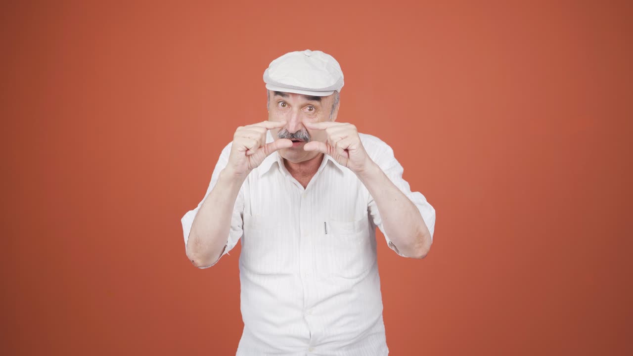 el anciano haciendo el pequeño signo con su mano.