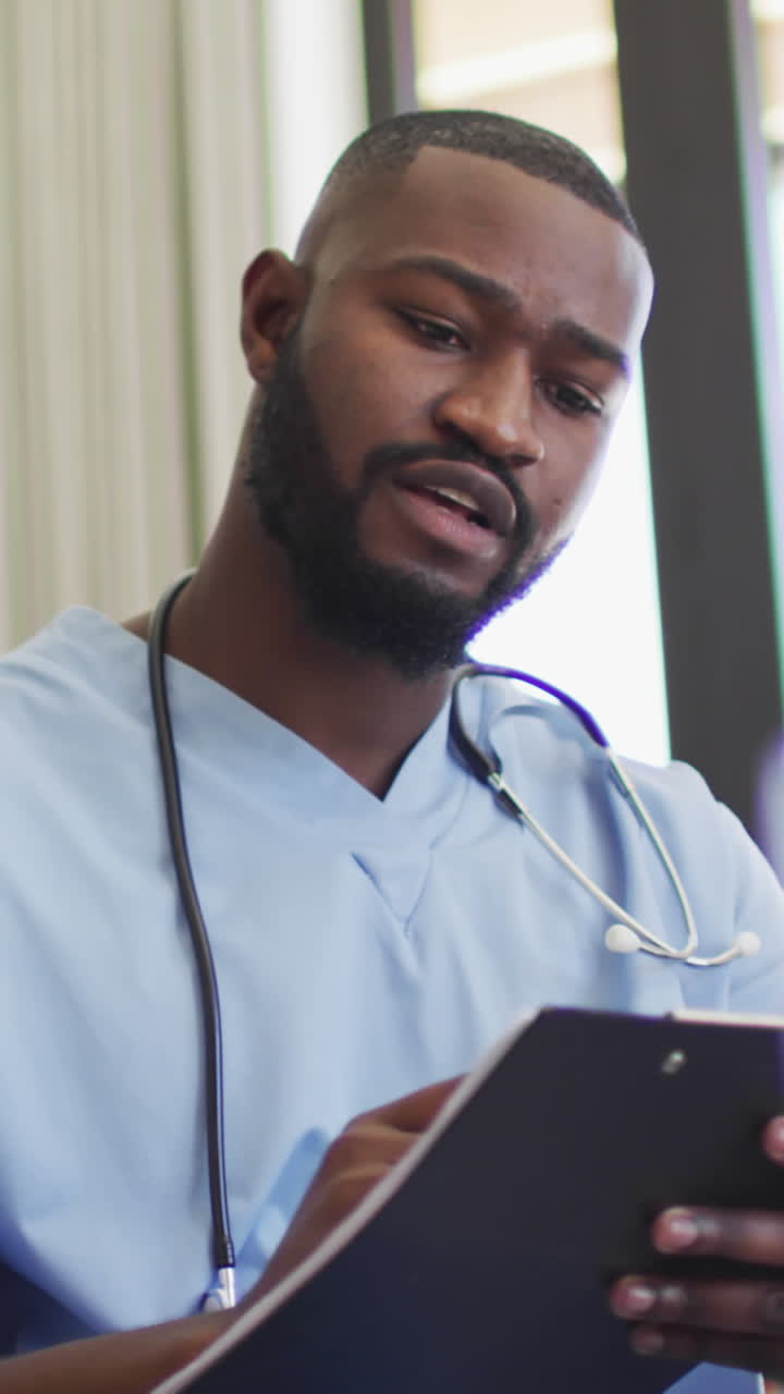 Video di un medico afroamericano che usa un tablet e somministra farmaci a una donna anziana caucasica