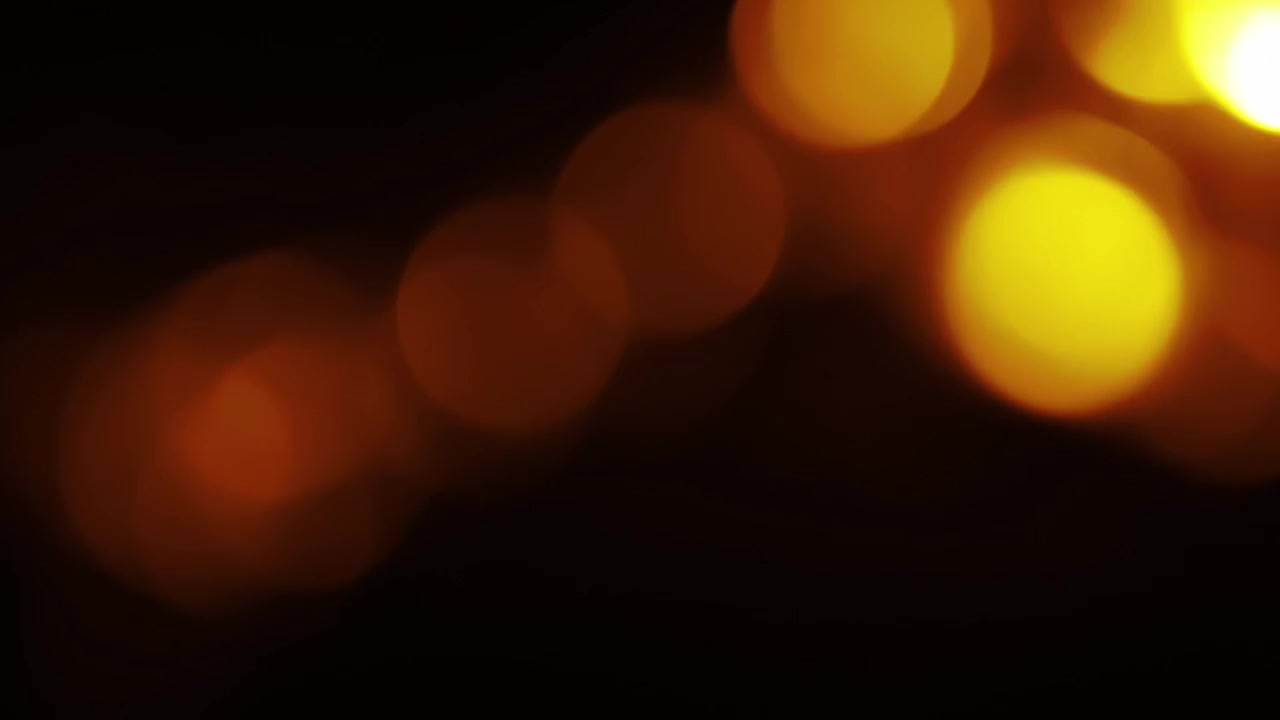 Luci bokeh calde arancioni e gialle che appaiono e scompaiono