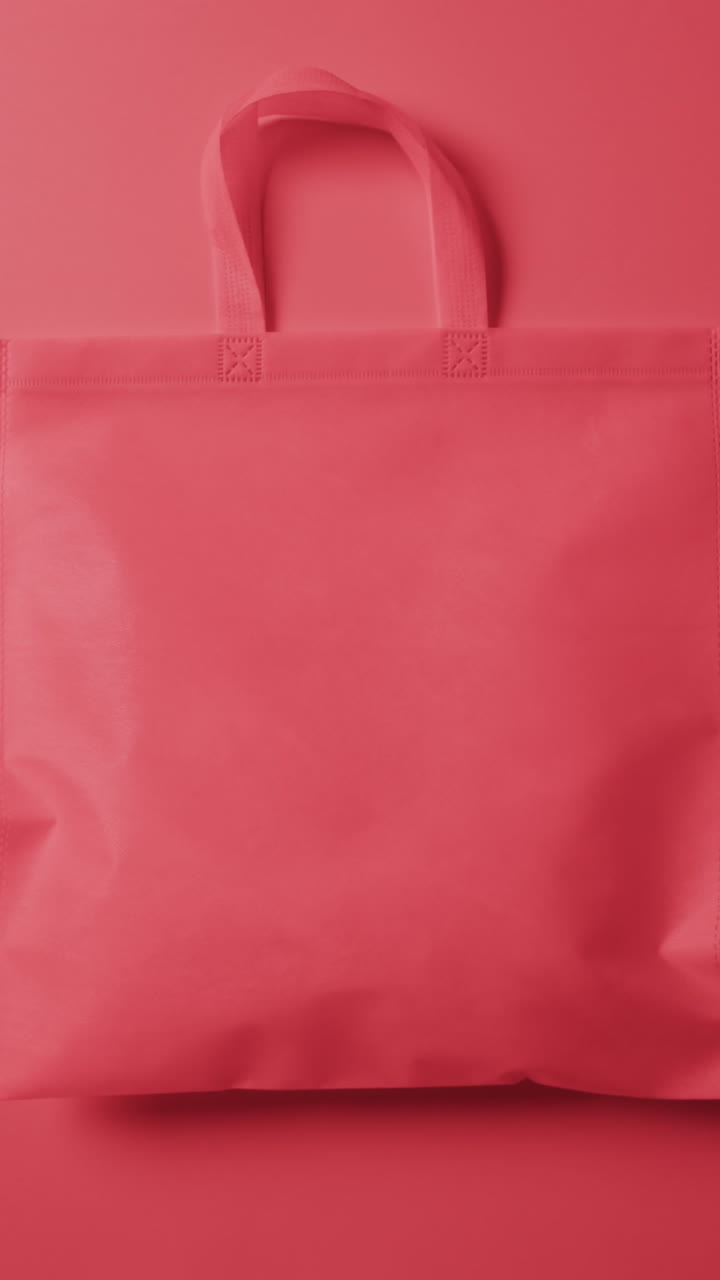 Vertical video of red canvas bag with copy space on red background