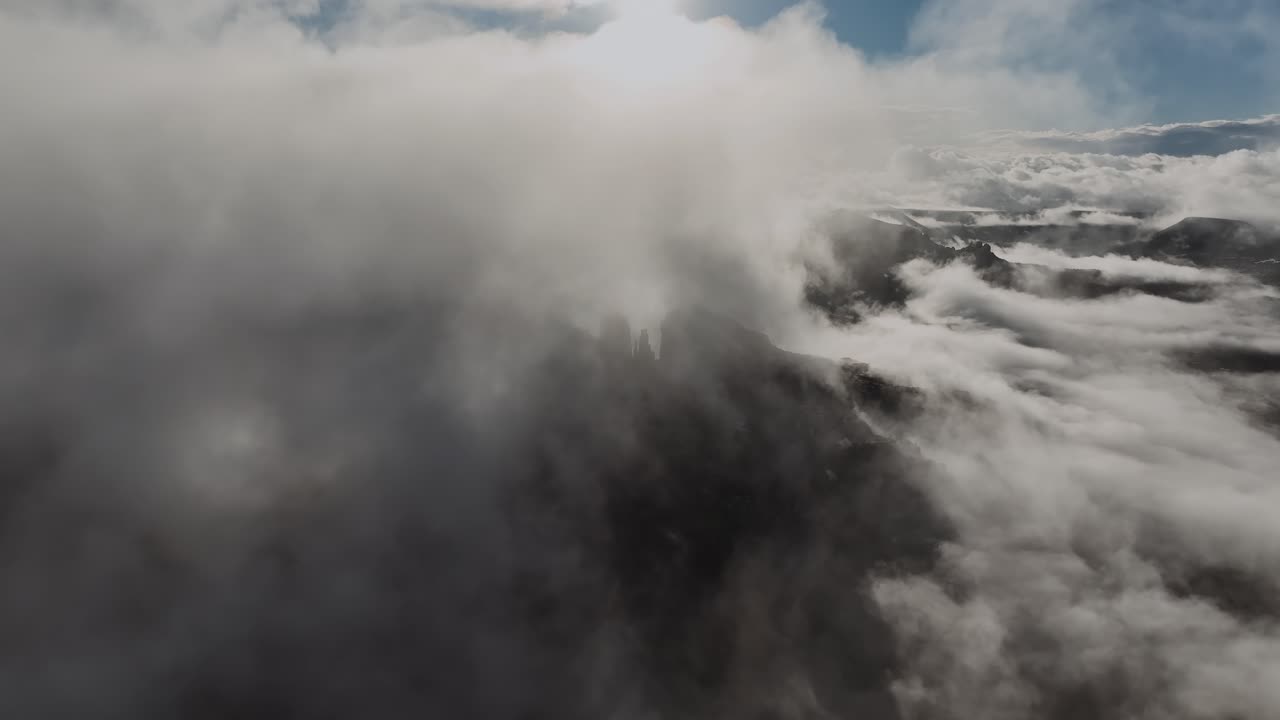el cielo oscuro cubierto de nubes sobre los picos de las montañas al amanecer