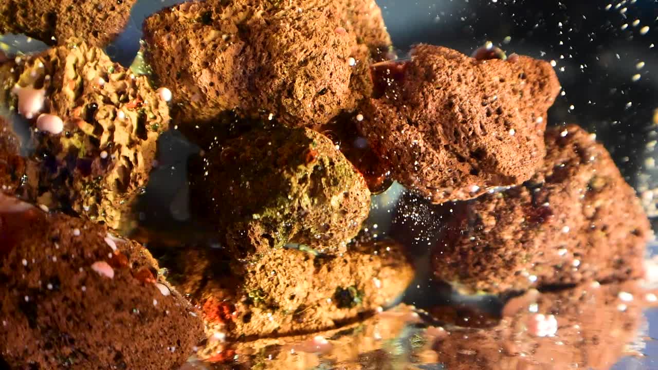 꿈 같은 수중 효과 60fps로 다공성 암석 외계 구조물 위로 떨어지는 천천히 움직이는 잔해