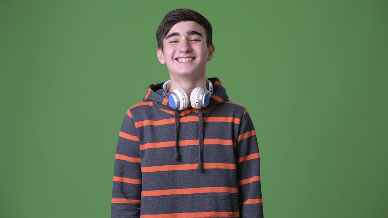 joven y guapo adolescente iraní contra un fondo verde