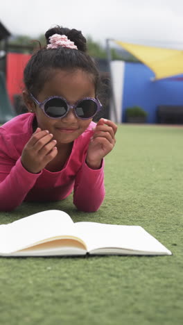 vertical video: in a school setting, a young asian girl is reading a book