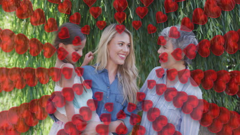 animation of hearts over happy caucasian three generation women family in garden