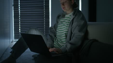 teenage girl using laptop at night