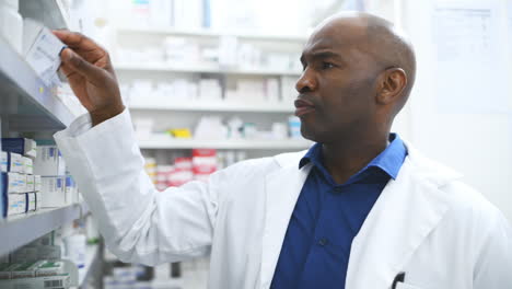 a-male-pharmacist-looking-at-products-on-the-shelf