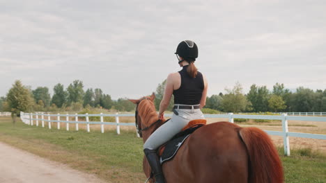 young woman and her red horse during a calm trail ride, handheld shot