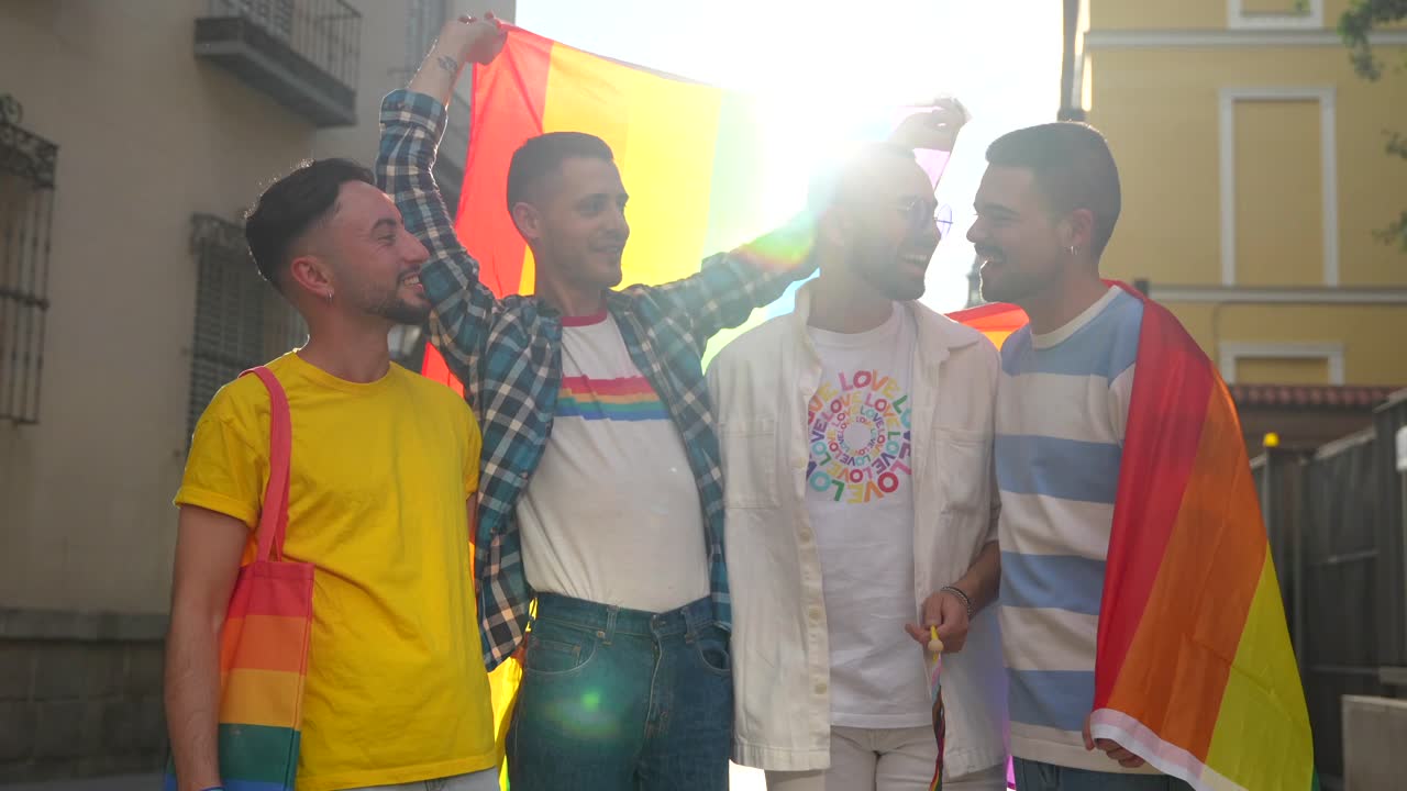A group of men celebrate LGBTQ pride with a rainbow flag