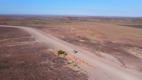 4x4 vehicle navigating desert rugged terrain at sunset - aerial