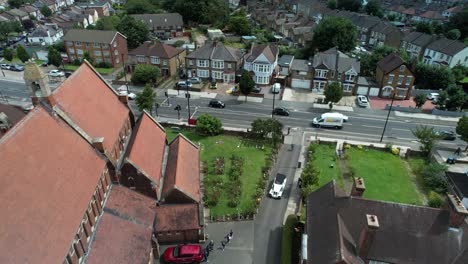 Posh-wedding-car-arriving-at-village-church-aerial-reverse-view-high-angle