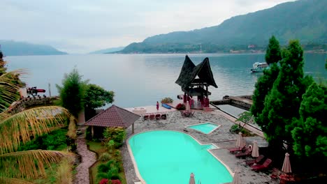 aerial fly over from the pool area of a tourist resort to lake toba, sumatra