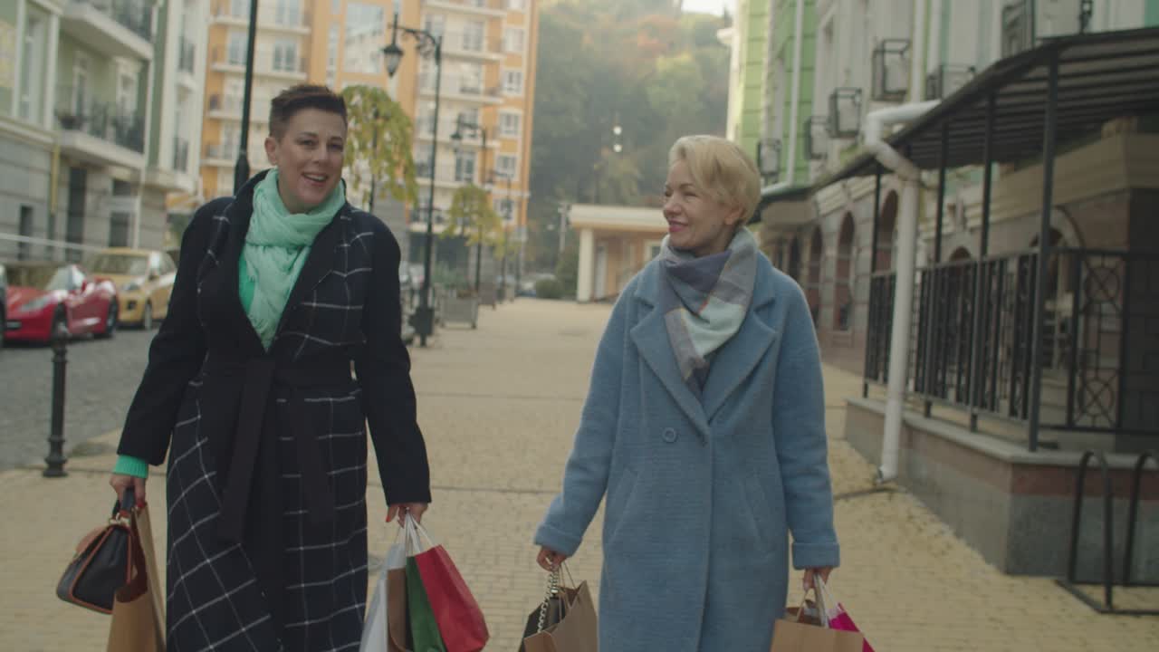 많은 종이 가방 을 들고 야외 에서 산책 하는 것 을 즐기는 노인 여성 들