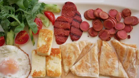 delicious turkish breakfast with eggs, cheese, sausage, bread and salad