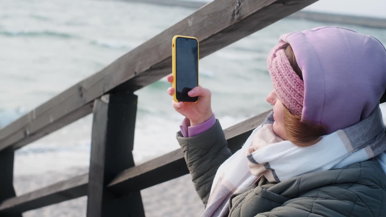 Woman taking a photo at the beach