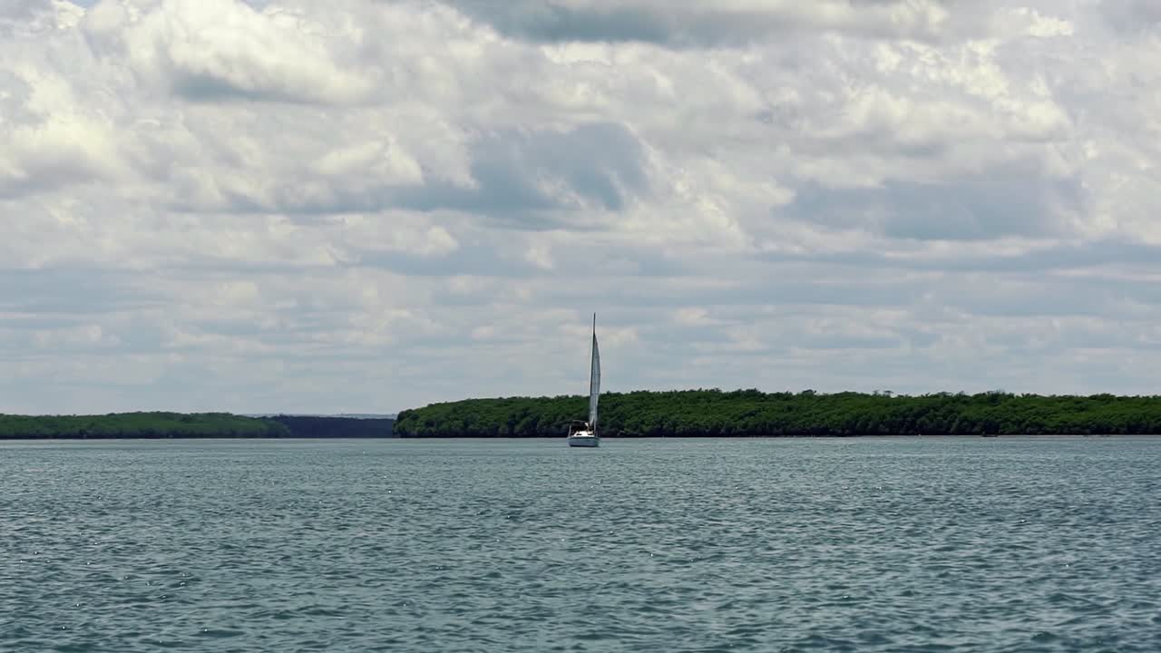 toma en cámara lenta de un velero navegando en un gran río lento cerca de la ciudad costera de barra do cunhaú en rio grande do norte, brasil en un día de verano