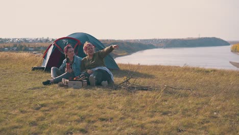 girls-look-at-something-interesting-near-bonfire-at-camp