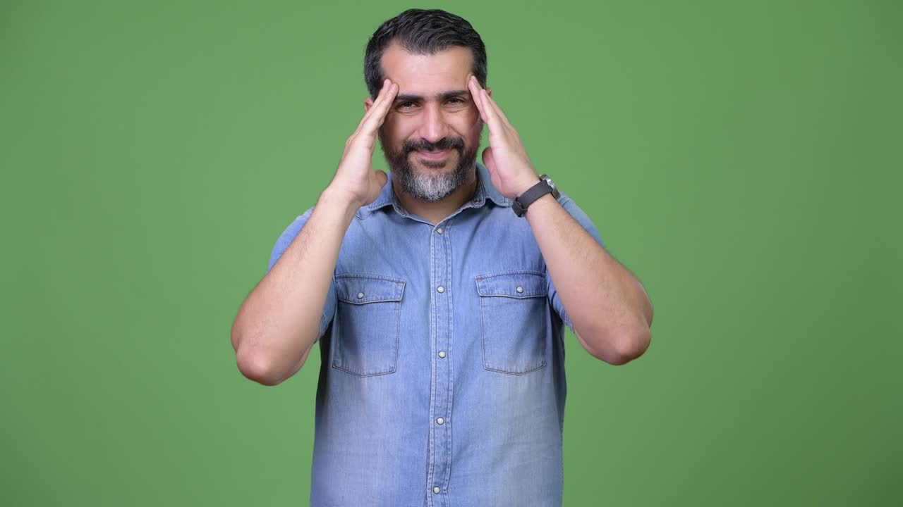 Handsome Persian bearded man having headache
