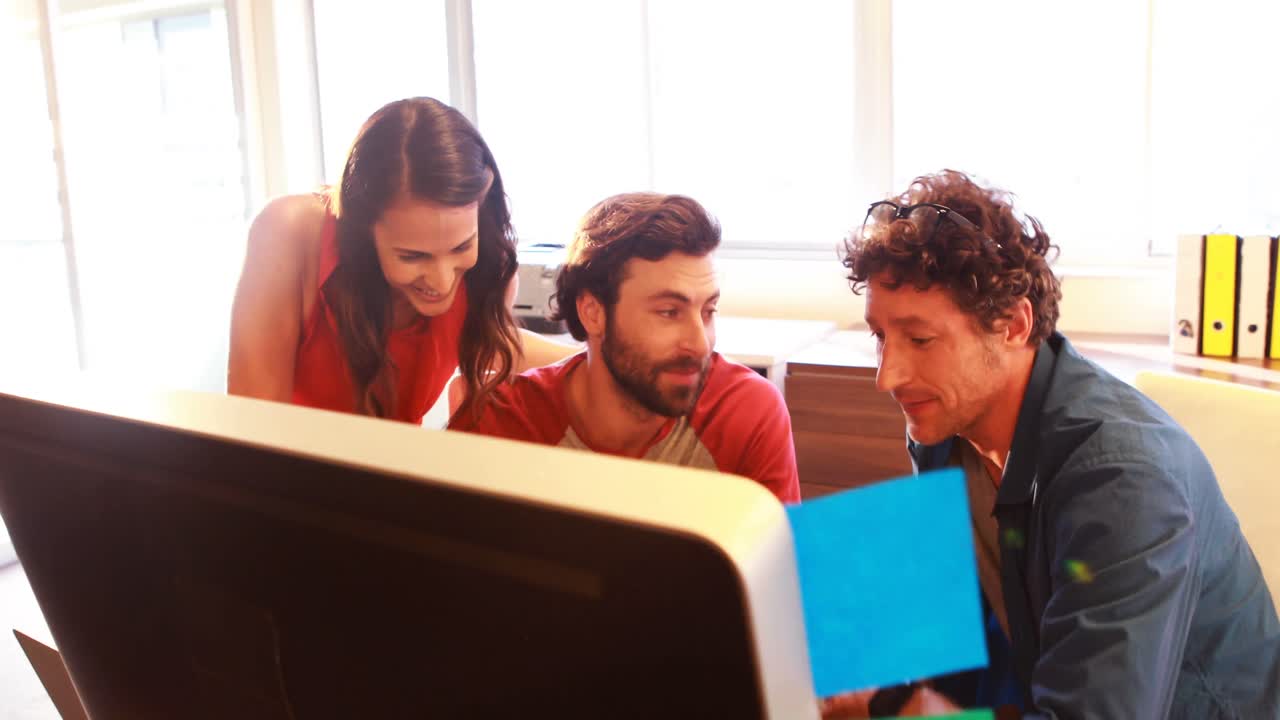 grupo de diseñadores gráficos interactuando mientras usan una tableta digital