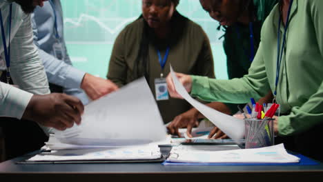 multiethnic forecasting team reviewing report files during important meeting
