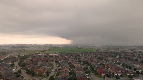 大規模的黑暗雷暴雲在美國城市郊區的居住區上空滾動