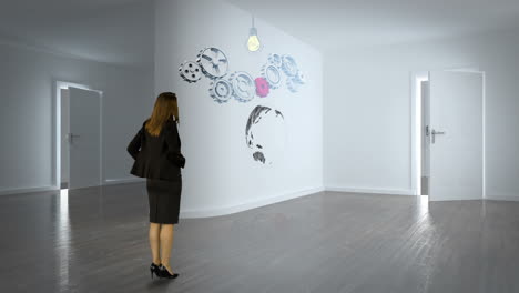 Businesswoman-watching-cog-and-wheel-on-wall