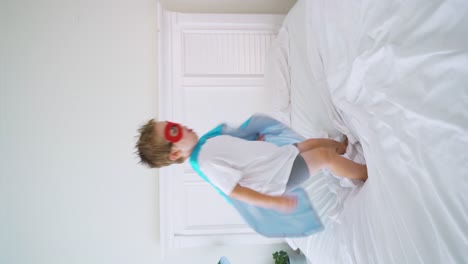 niño superhéroe saltando en la cama