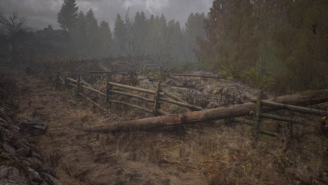 una vieja valla de madera con un campo de campo detrás de ella